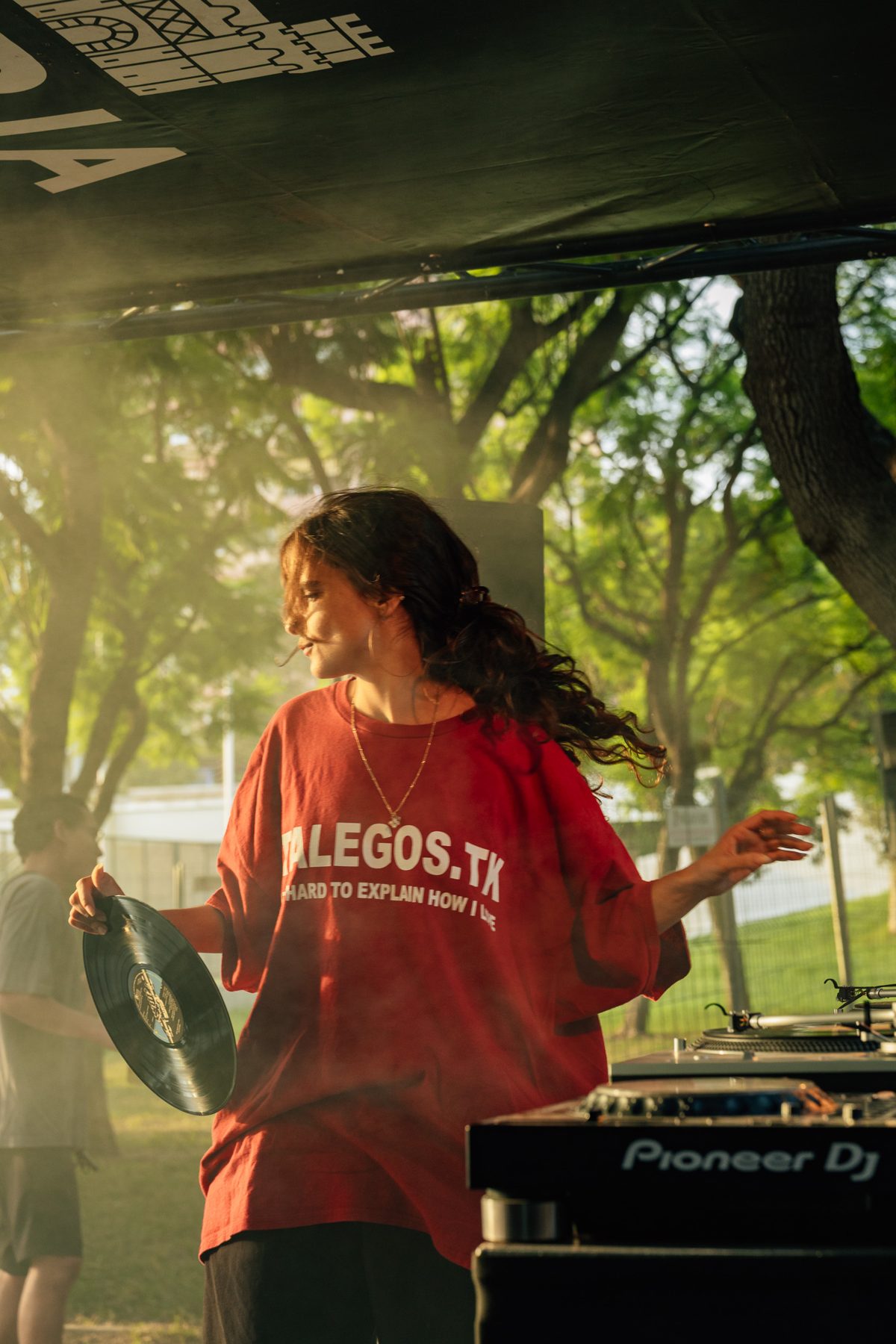 DJ con camiseta roja bailando con un vinilo en la mano