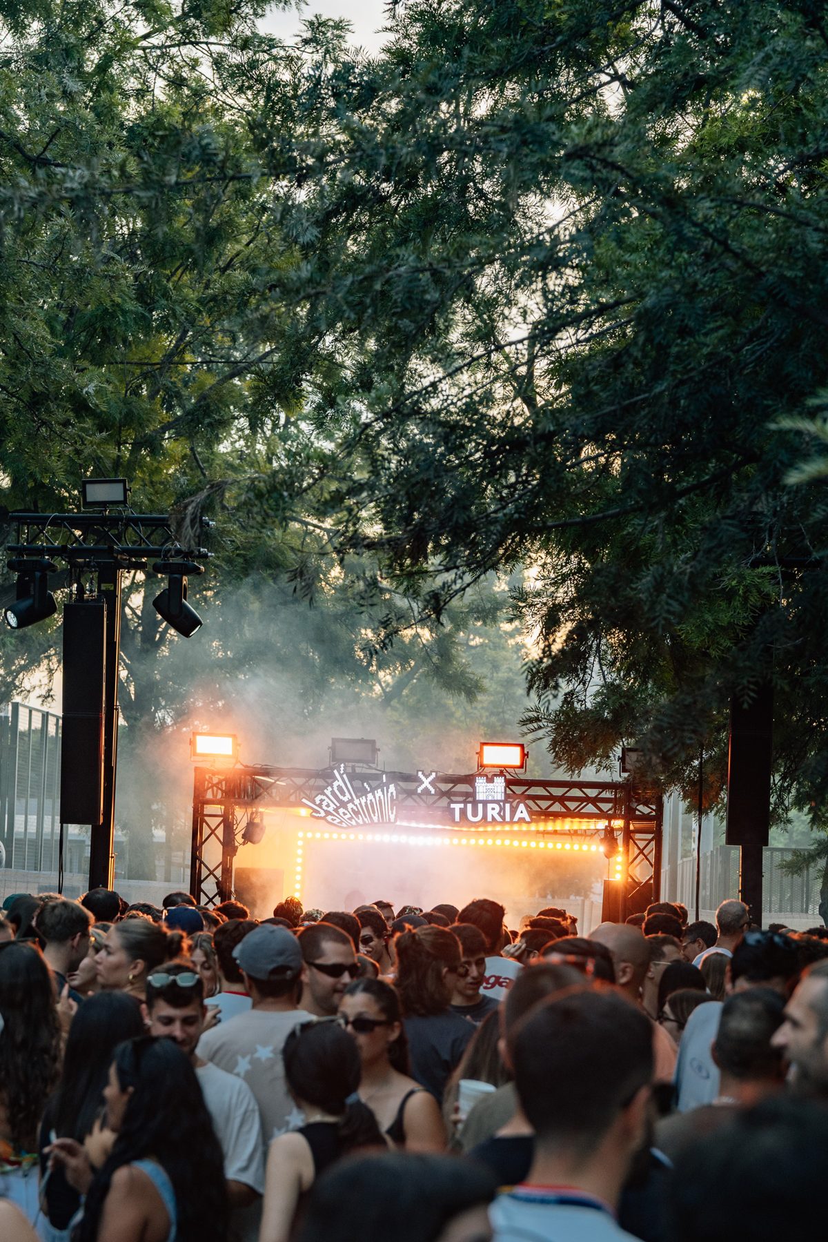 Público bailando frente al escenario de Jardí Electrònic x Túria al atardecer