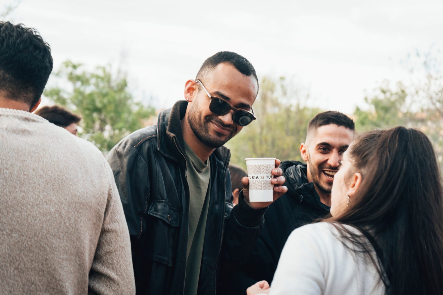 Asistente sonriendo con un vaso de Túria